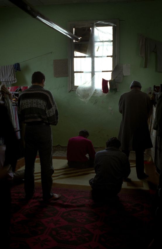 Greece, Artist: Nikos Pilos, Title: Praying in poverty,  NEW FACE OF POVERTY: Just arrived from Africa an Asia to the reception centre in the island of Mytilini ( Greece )